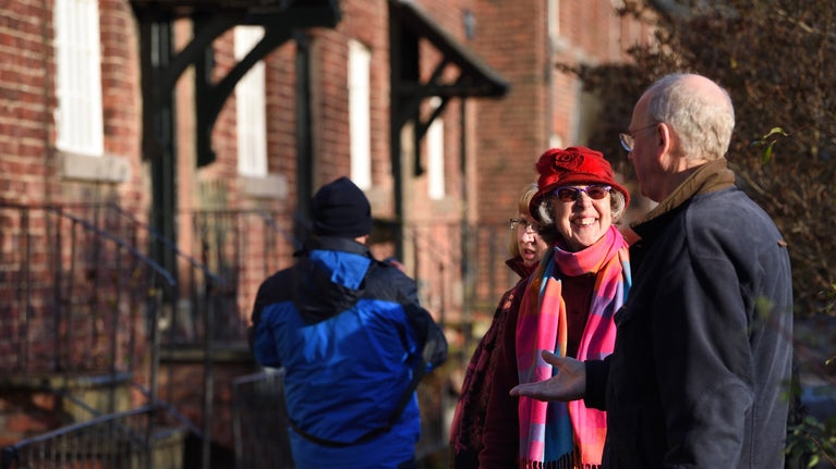Visitors outside the row of terraced cottages in the village of Styal, built by the Greg family to house workers at their nearby Quarry Bank Mill, Cheshire